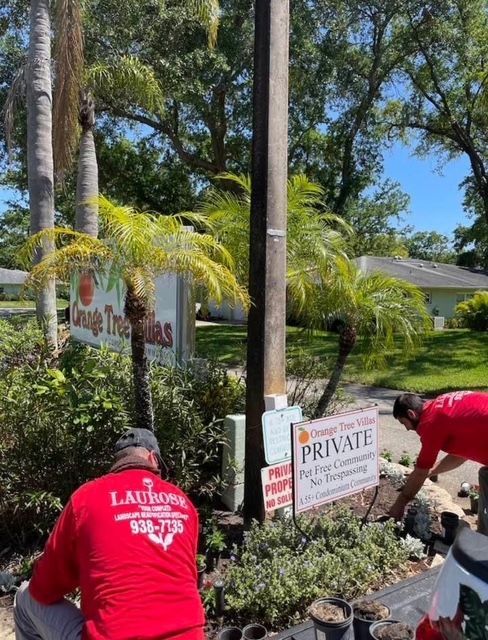 Two men in red shirts are working in front of a sign that says private