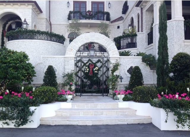 A large white house with pink flowers in front of it