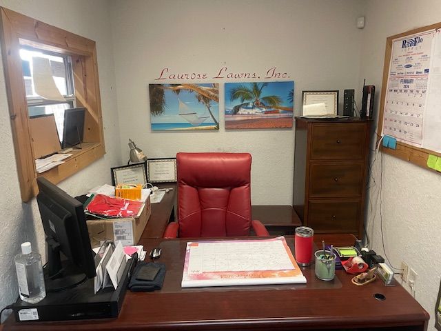 A desk with a red chair and a computer on it