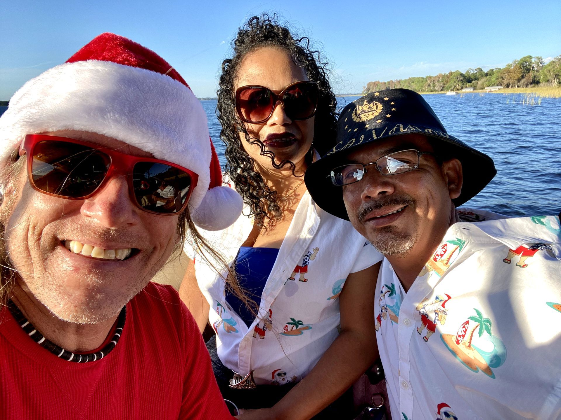 A man wearing a santa hat is posing for a picture with two other people.