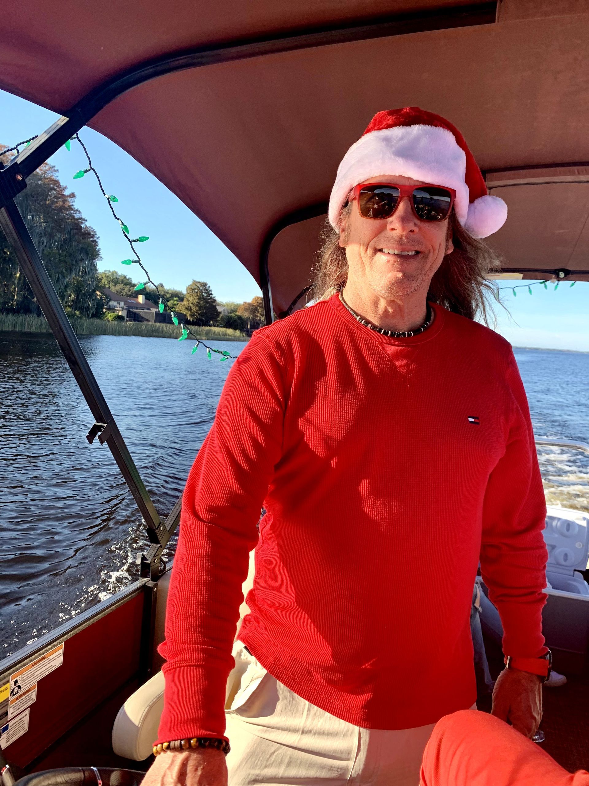 A man wearing a santa hat is sitting on a boat