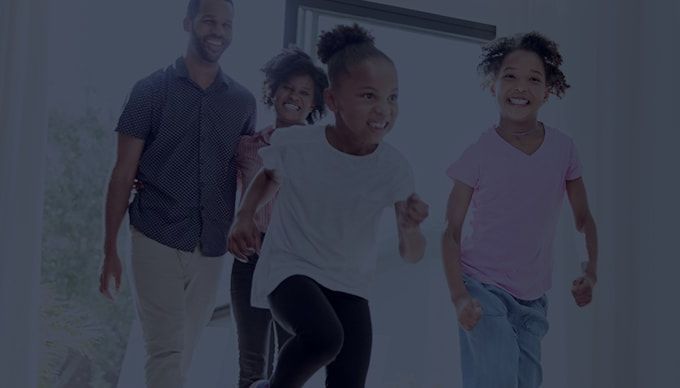 A family is standing next to each other in a living room.