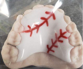 A close up of a denture with red stitching on it.