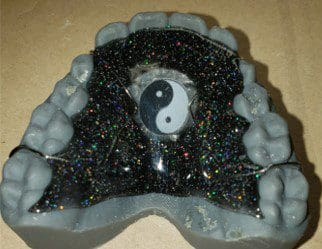 A model of a person 's teeth with a yin yang symbol on it.