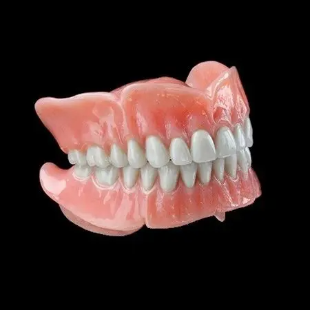 A full denture with white teeth on a black background.