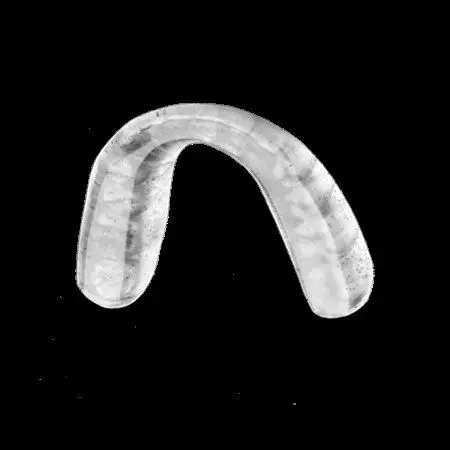 A white mouth guard on a black background.