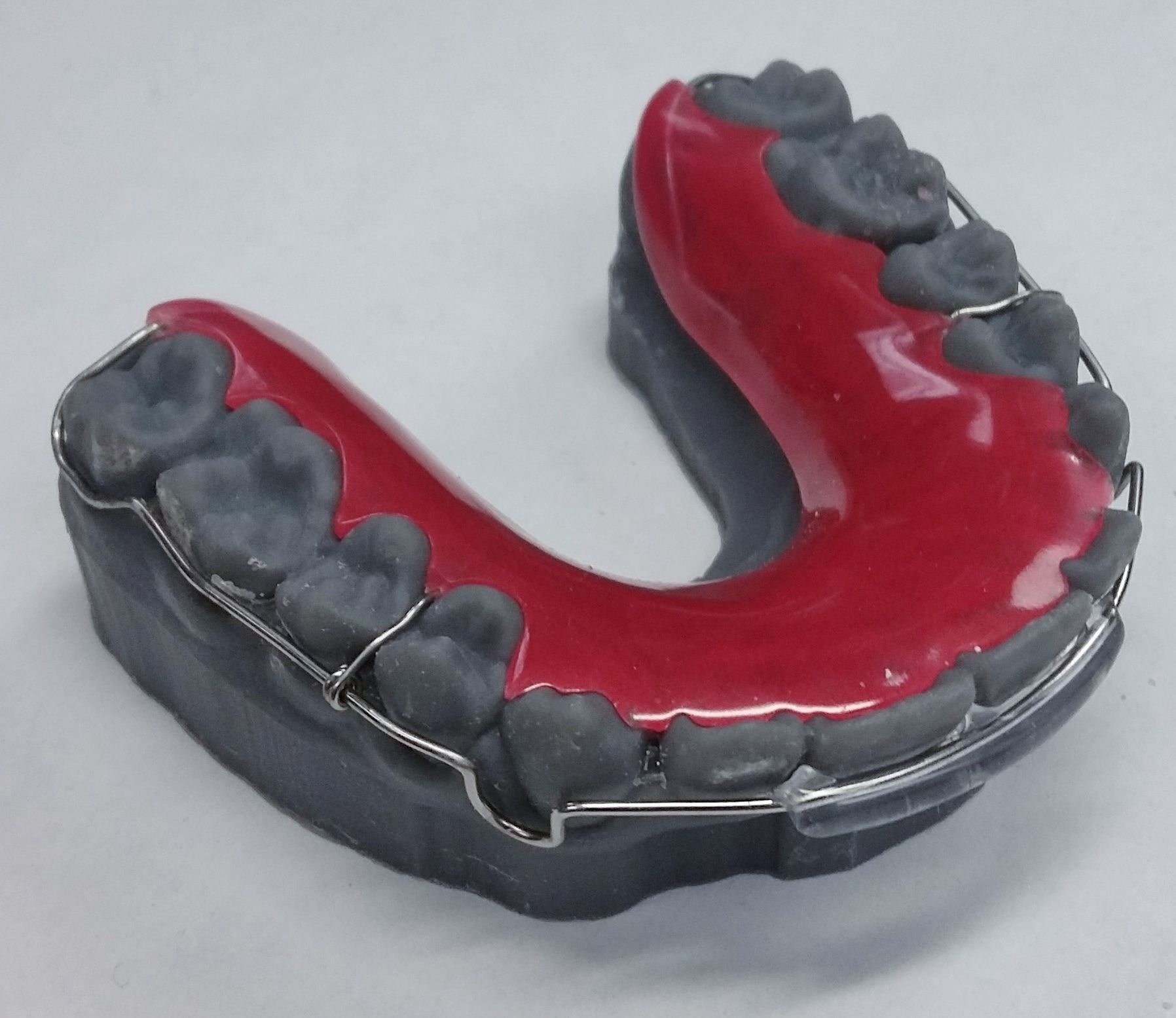A model of a mouth with gray teeth and red gums