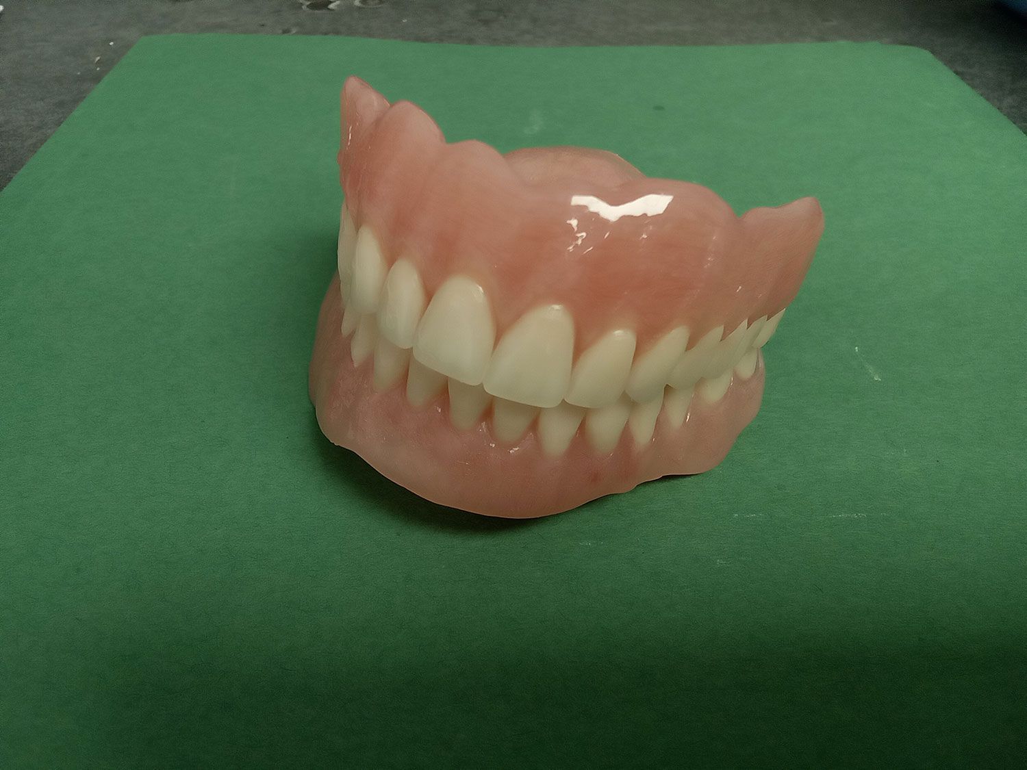 A denture is sitting on top of a green mat.