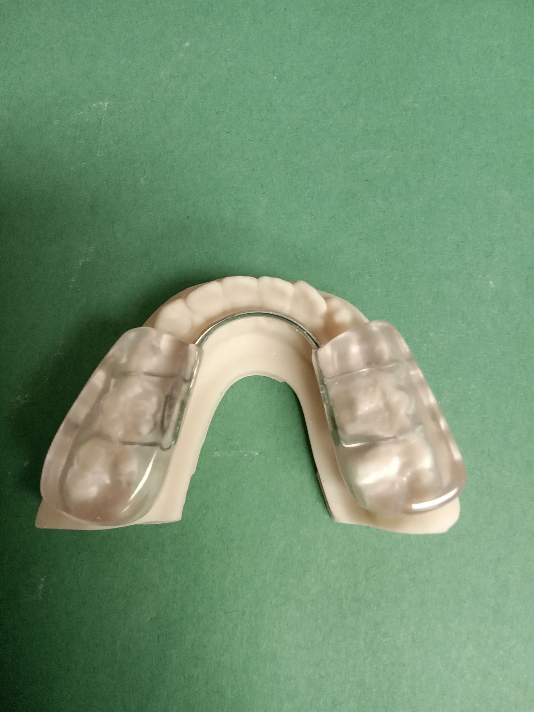 A mouth guard is sitting on top of a green table.