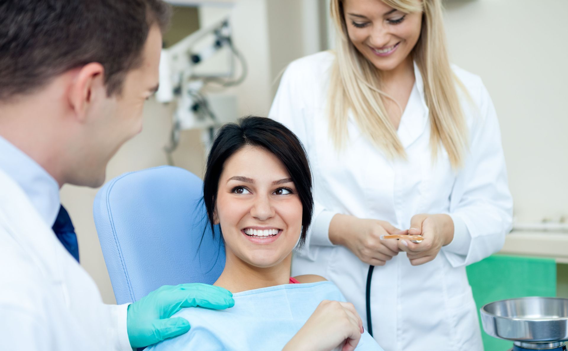 A woman is sitting in a dental chair talking to a dentist.