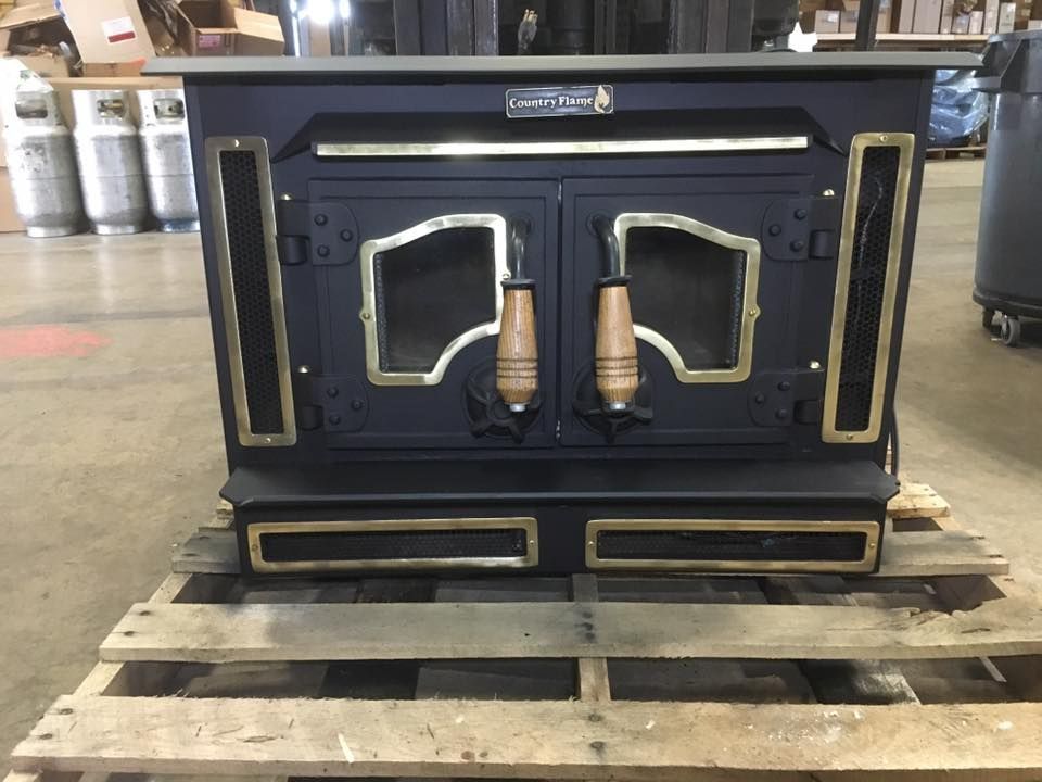 A black wood stove is sitting on a wooden pallet