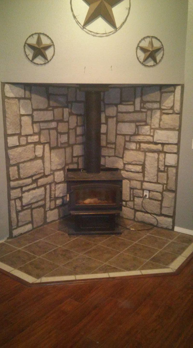 A fireplace with a stone wall and a wood stove