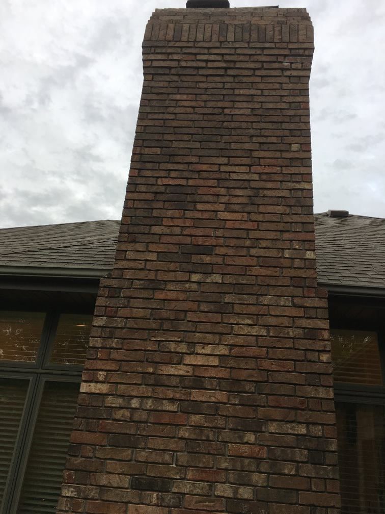 A large brick chimney on the side of a house.
