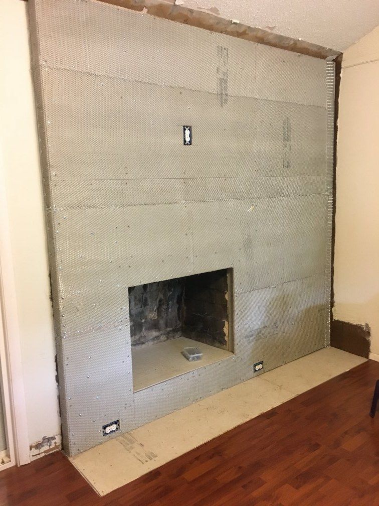A fireplace is being remodeled in a living room.