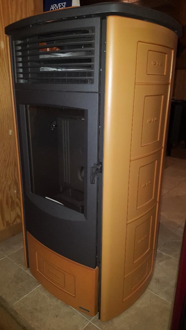 A wood stove is sitting on a tiled floor in a room.