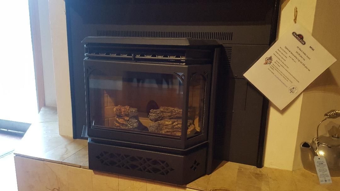 A fireplace with a tag attached to it is sitting on a mantle.