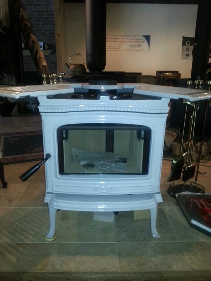 A white wood stove is sitting on a tiled floor
