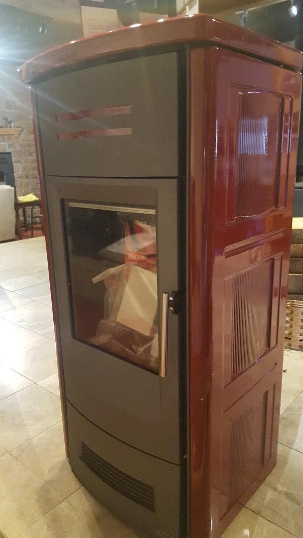 A wood stove is sitting on a tiled floor in a room.