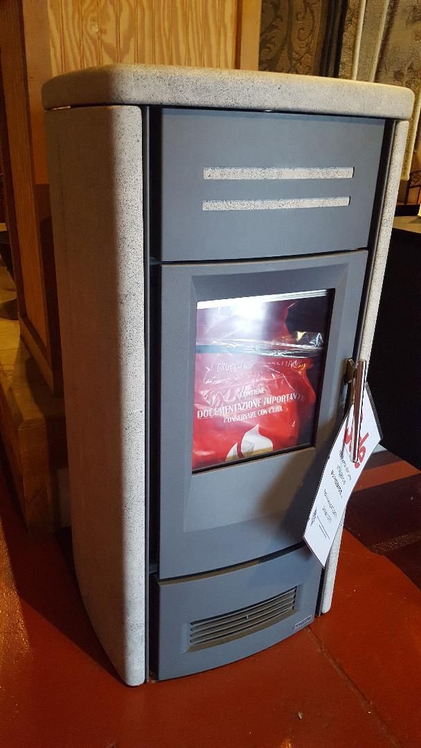 A stove with a tag on it is sitting on a red floor.