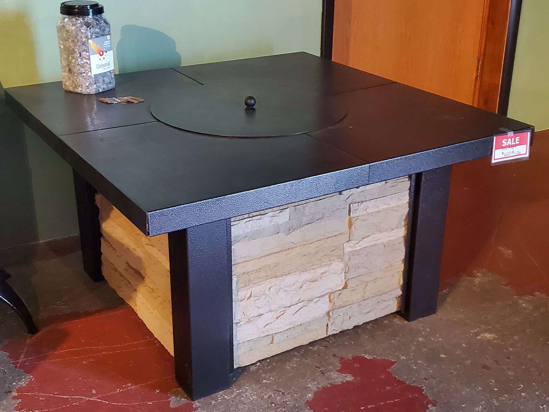 A black table with a jar of beads on top of it