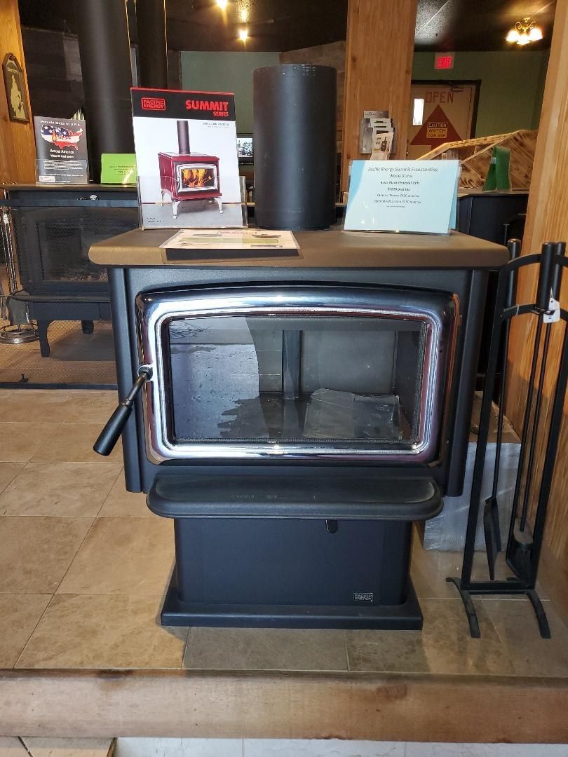 A black wood stove is sitting on a tiled floor in a room.