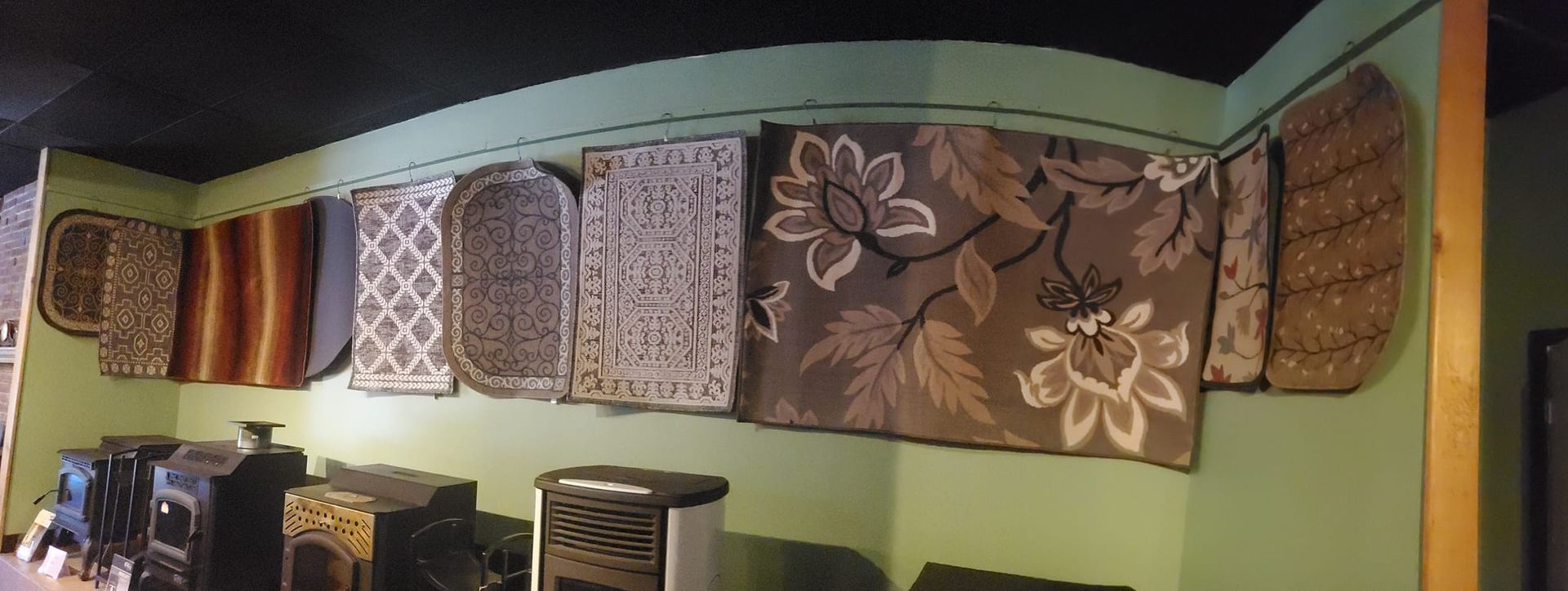 A room with a lot of rugs hanging on the wall