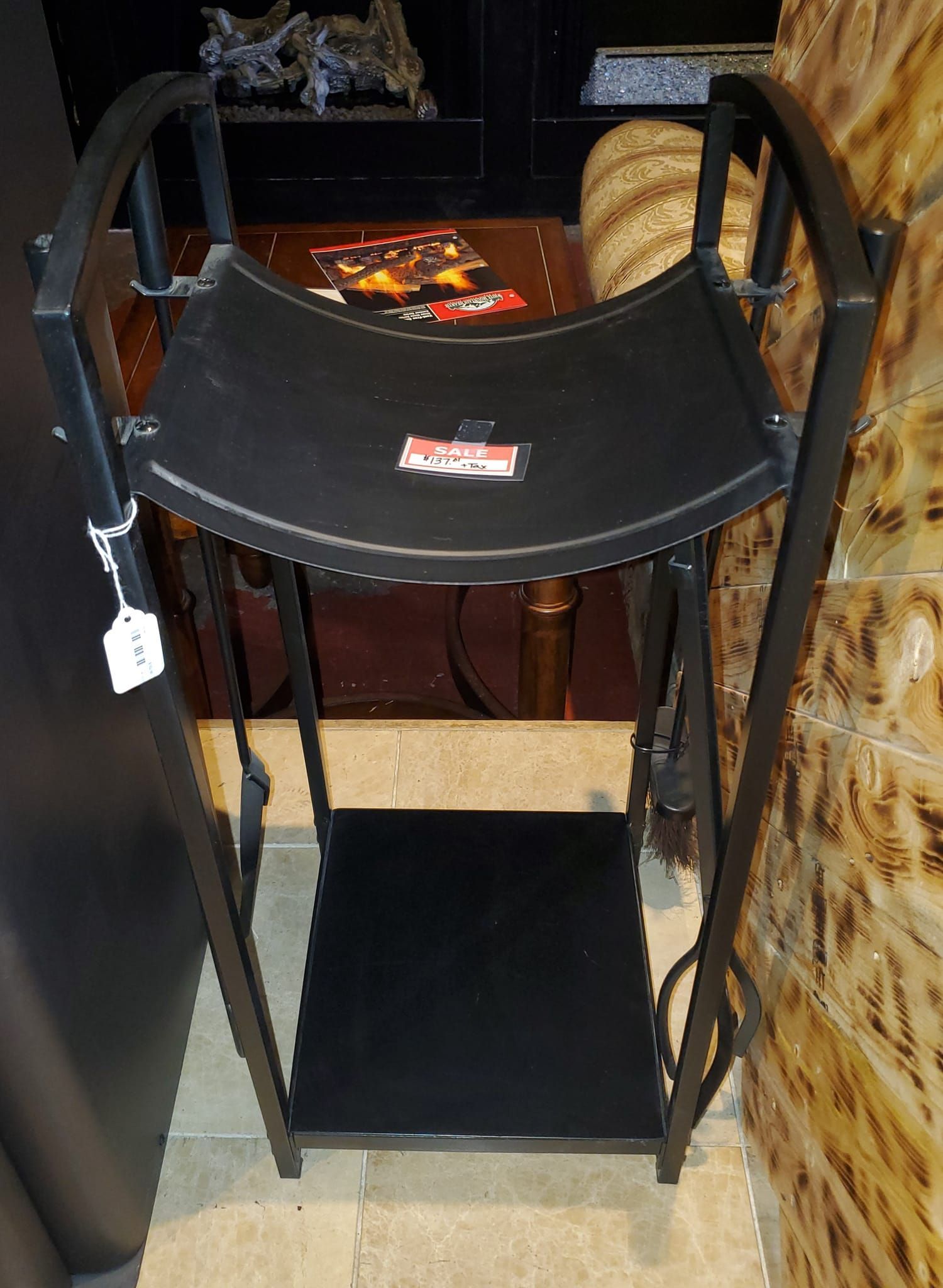 A black chair is sitting on a tiled floor next to a table.