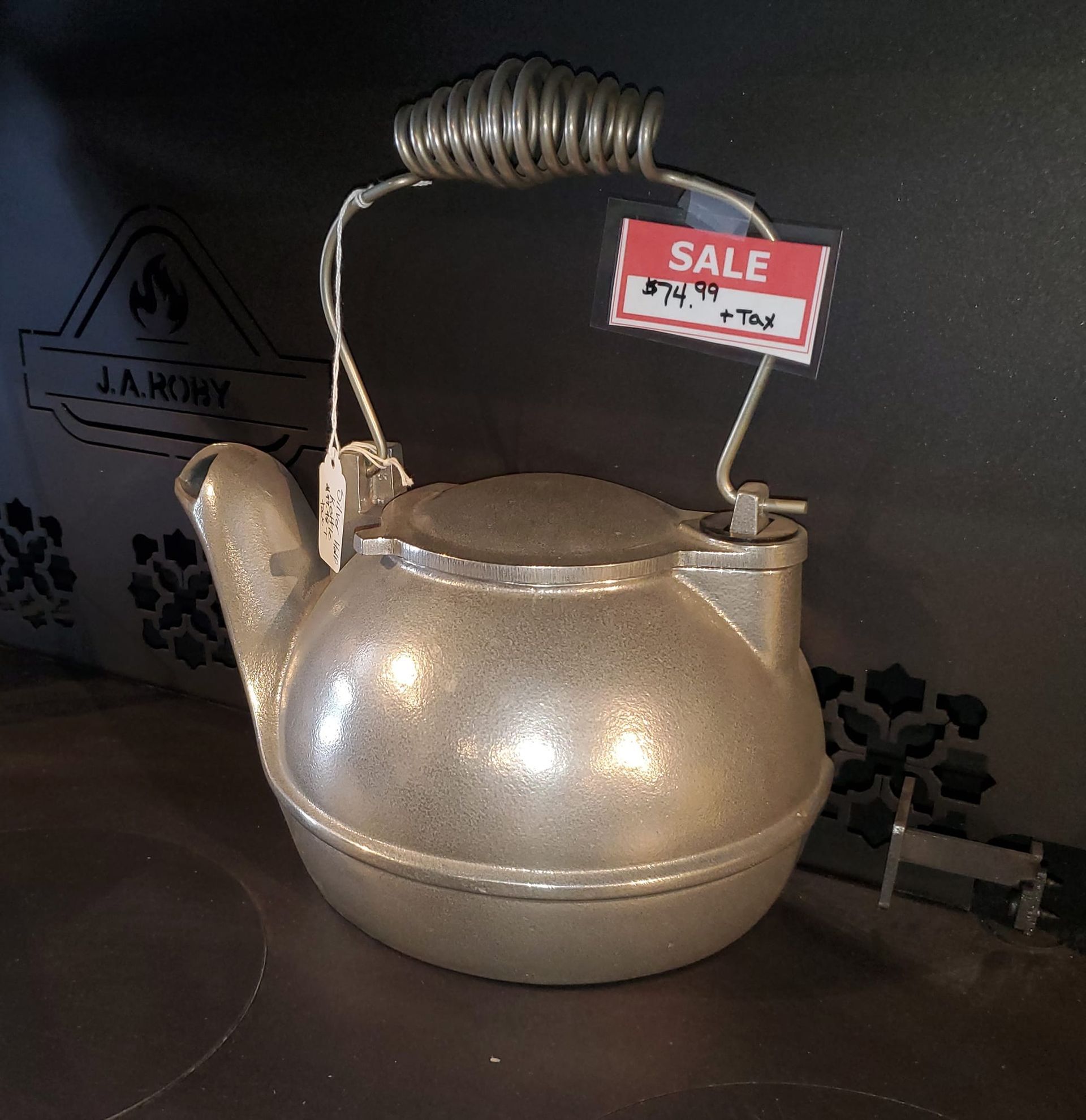A silver tea kettle with a sale tag attached to it