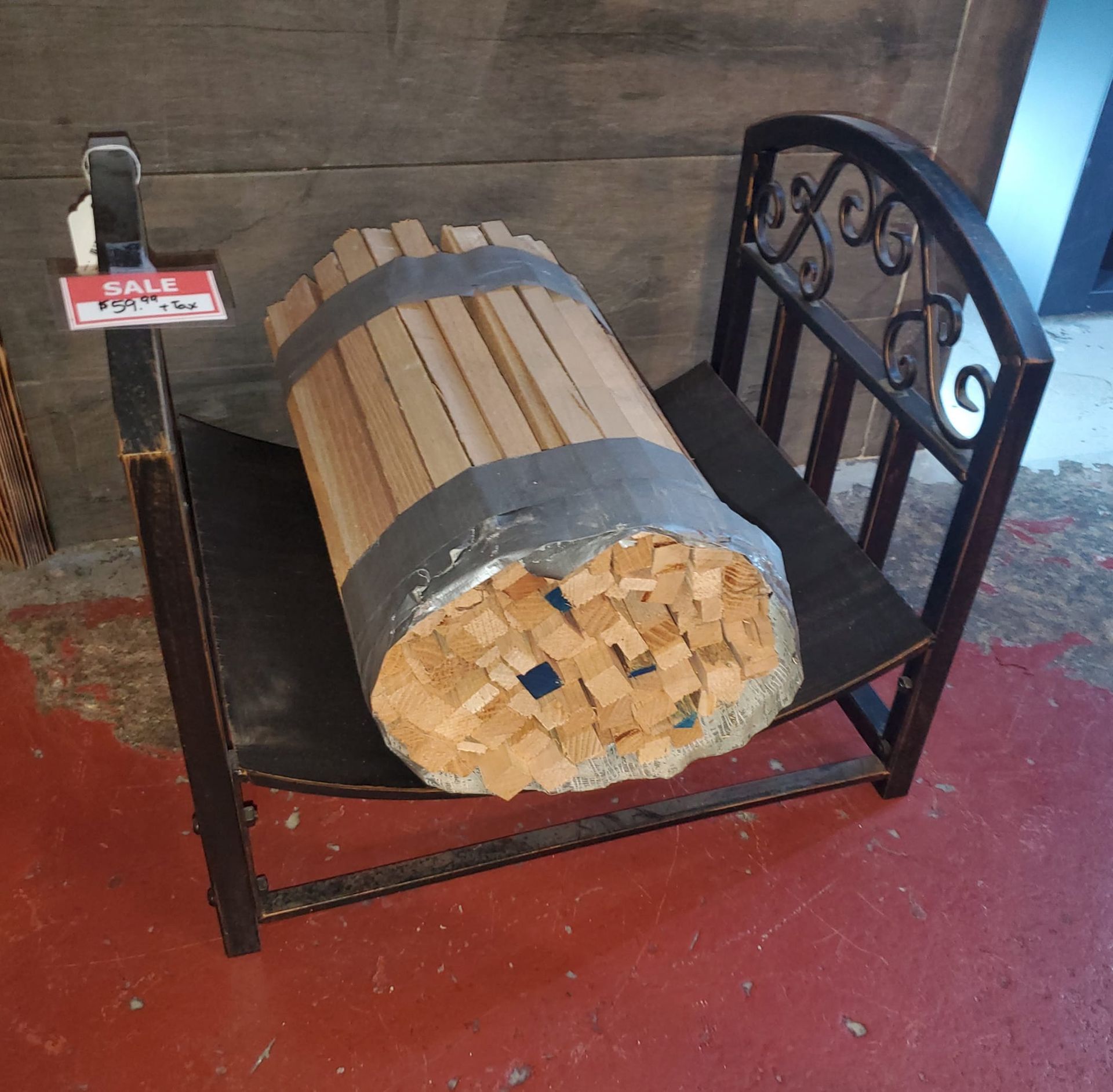 A wooden barrel sits on a chair with a sale sign above it