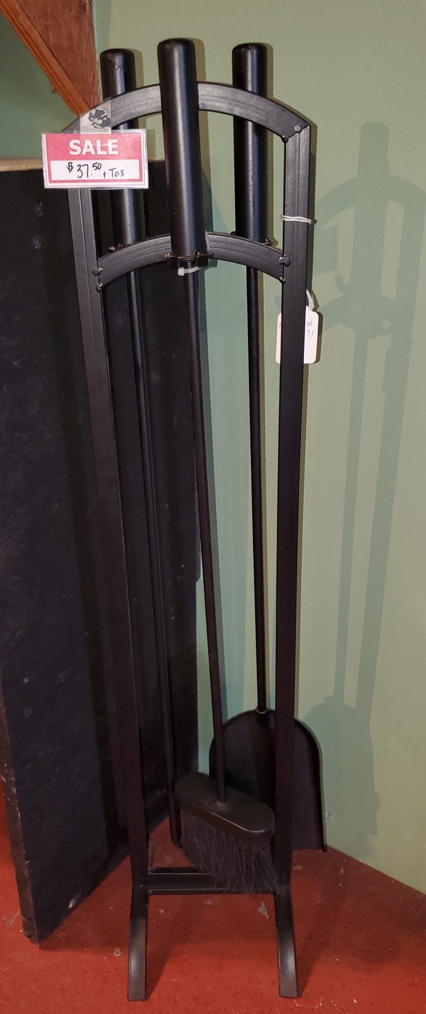 A black fireplace tool set is sitting in a corner of a room.