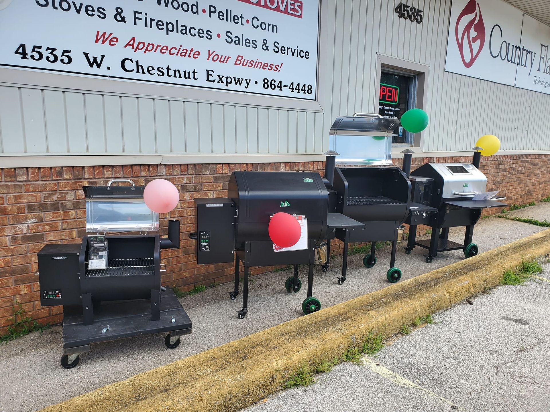 A row of grills are lined up in front of a building.