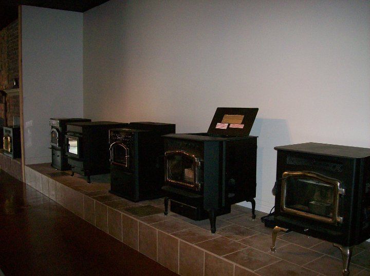 A row of wood stoves are lined up in a room.