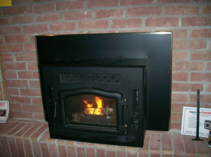 A brick fireplace with a wood stove in it