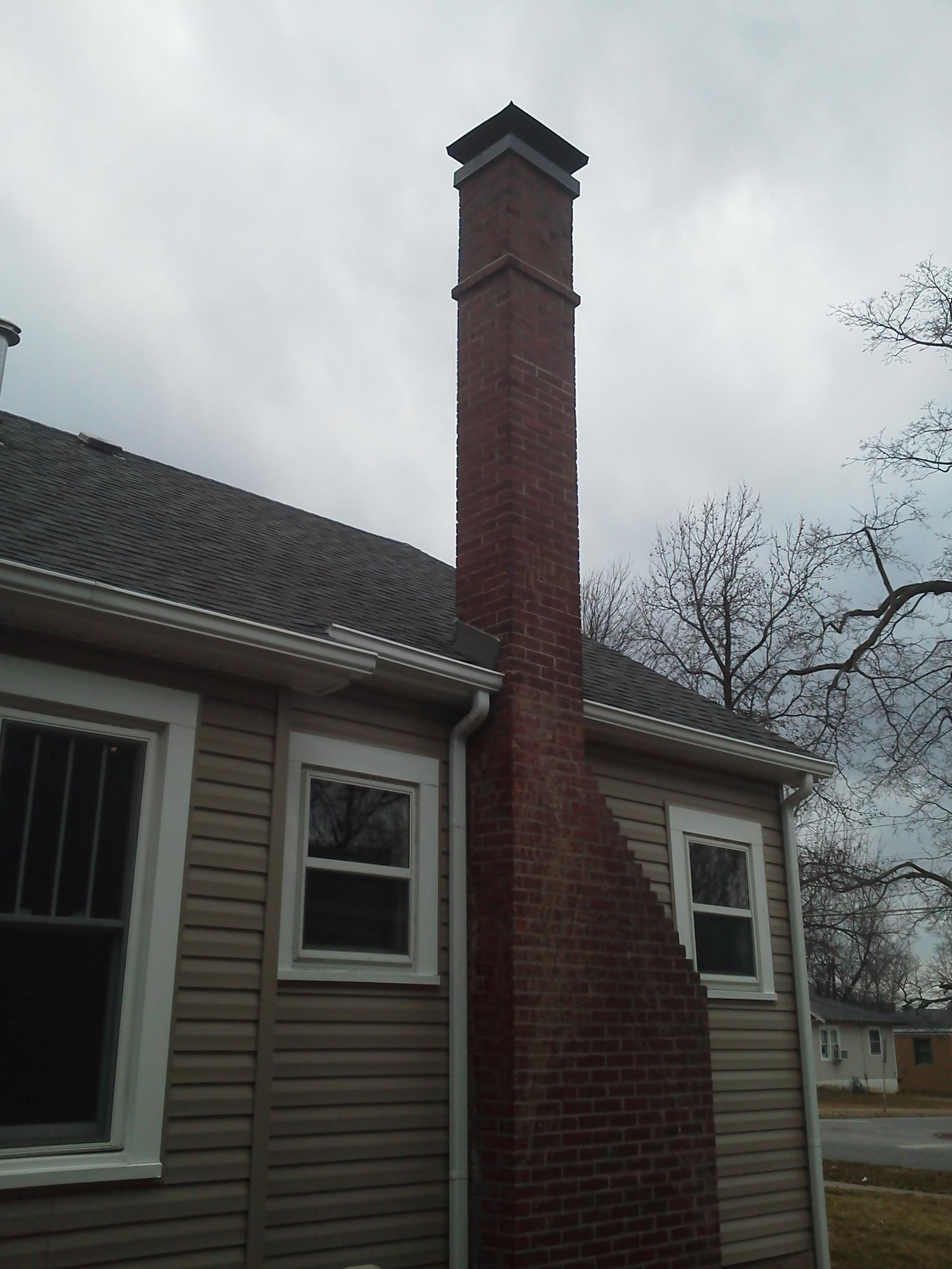 A brick chimney on the side of a house
