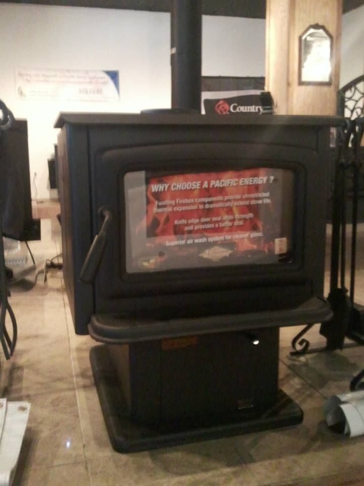 A black wood stove with a sign that says why choose a pacific pellet