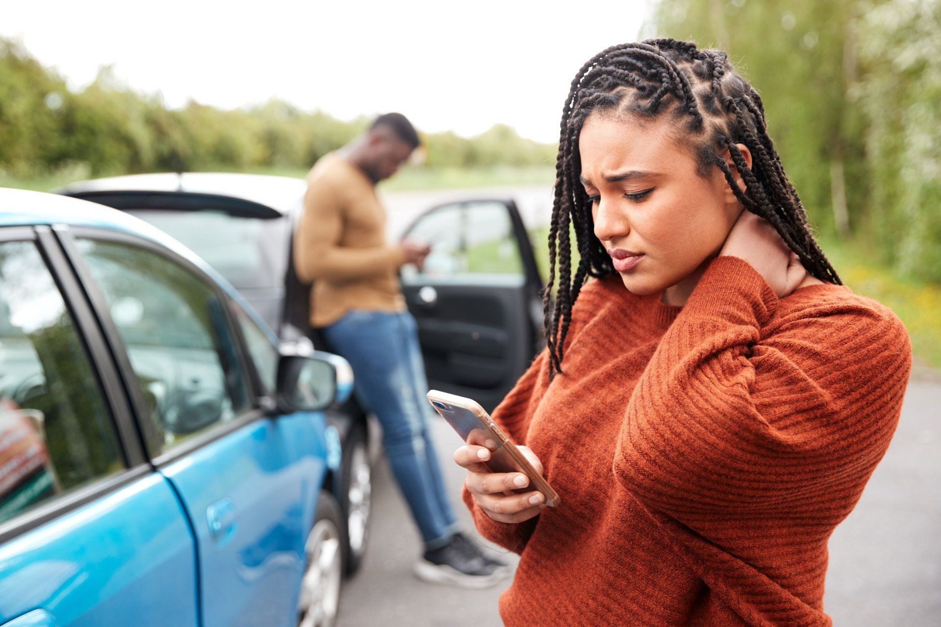 Woman with a painful neck trying to use her cell phone