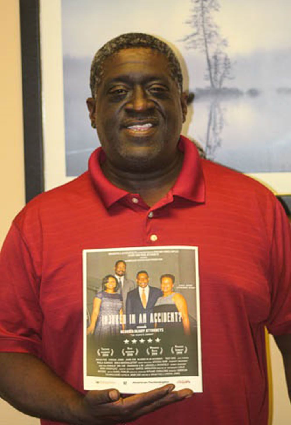 A man in a red shirt is holding a flyer