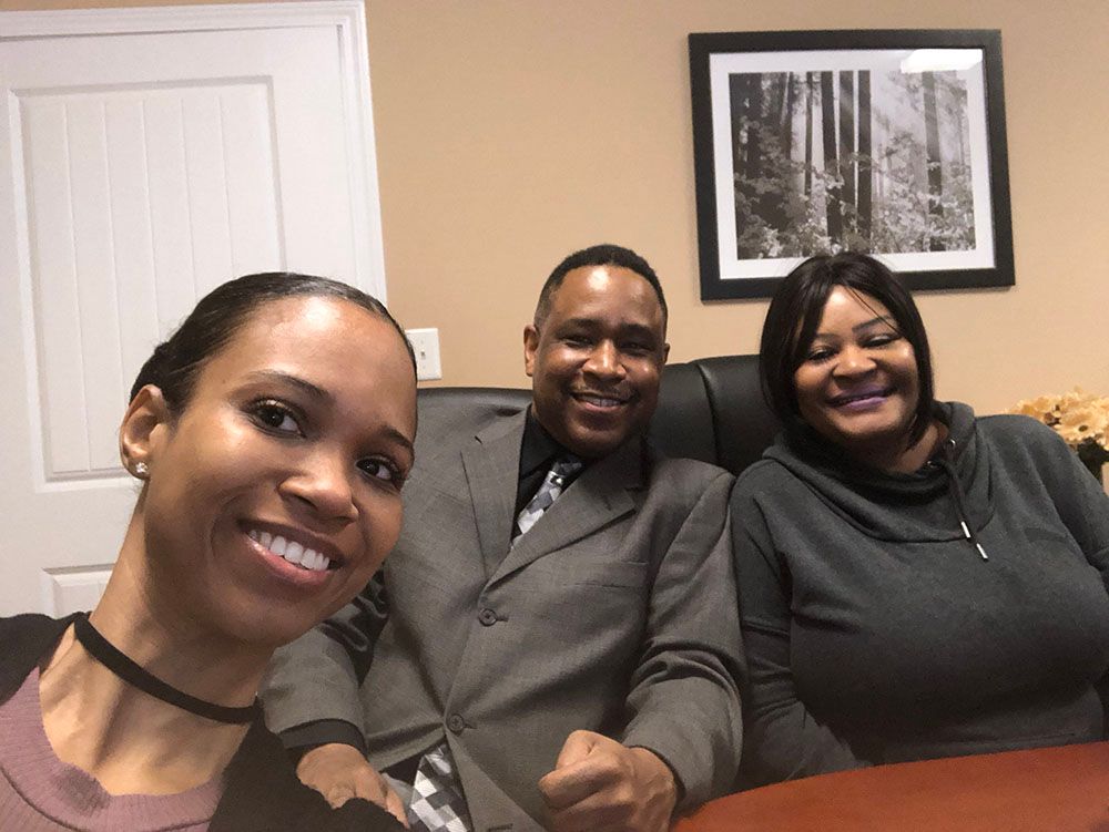 Brian D. Poe, Esq. and two women are posing for a picture while sitting at a table