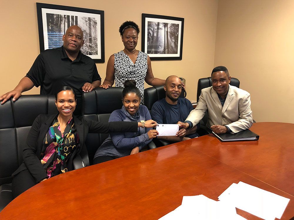 A group of people are sitting around a conference table