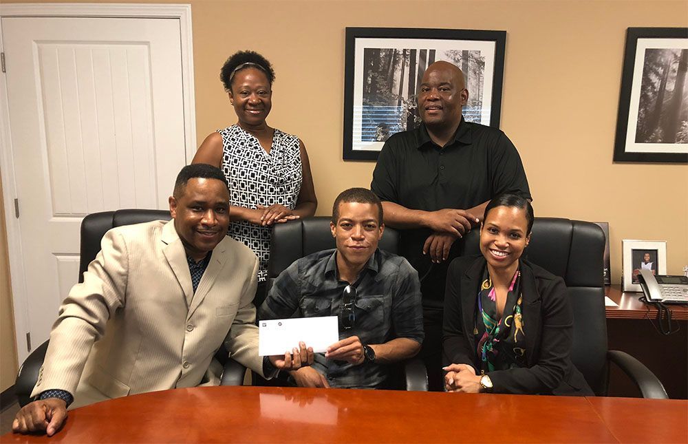 A group of people are posing for a picture while sitting around a table