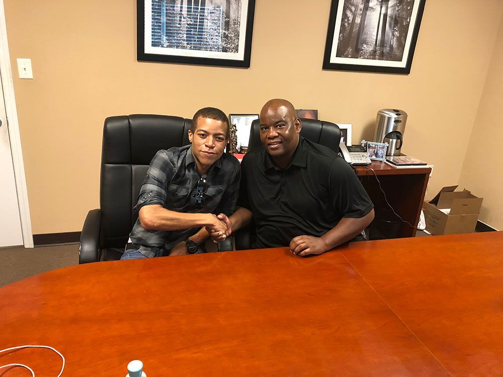 Brian D. Poe, Esq. and his client shaking hands