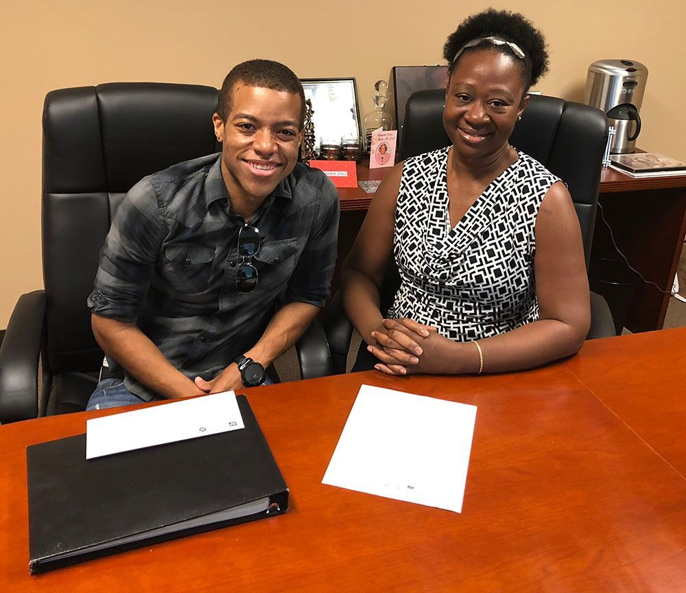 A man and a woman are sitting at a table with papers on it