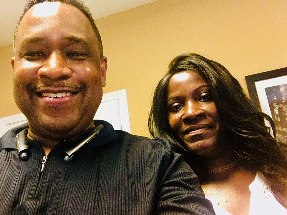 A man and a woman are posing for a picture together and smiling