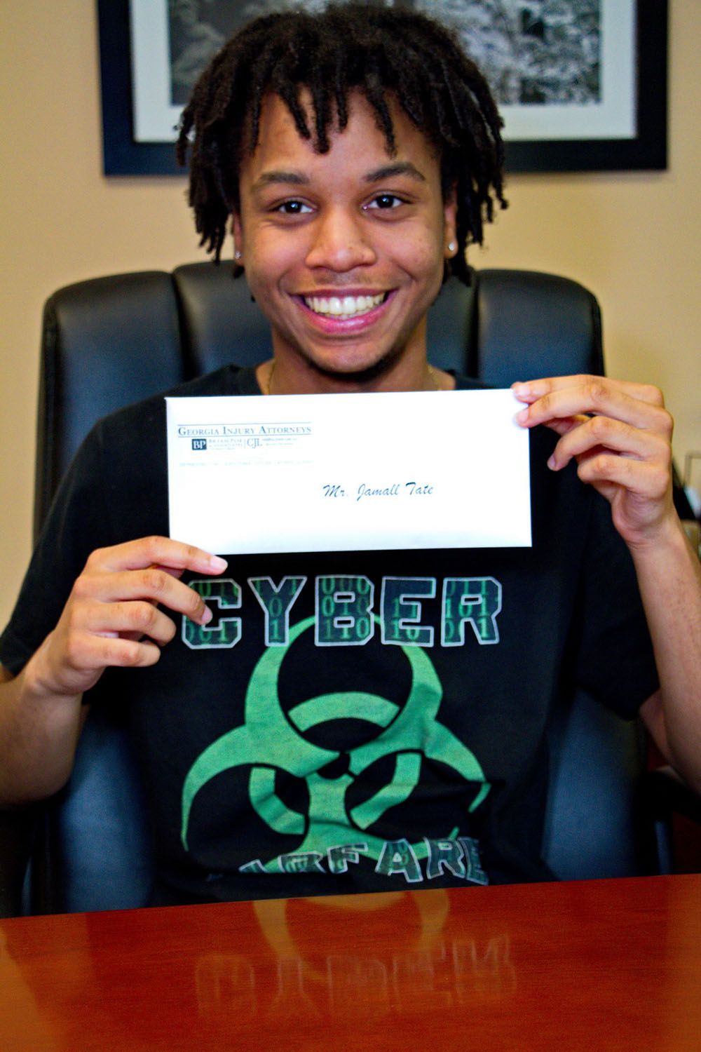 A man in a black shirt holds up an envelope