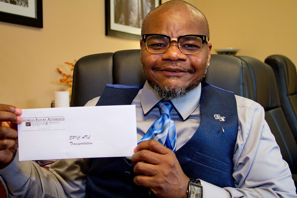 A man in a suit and tie is holding an envelope in his hands