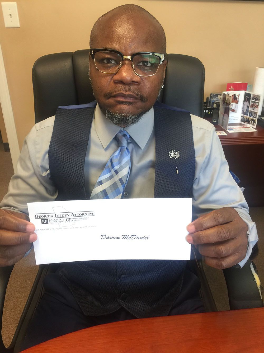 A man in a suit and tie is holding an envelope