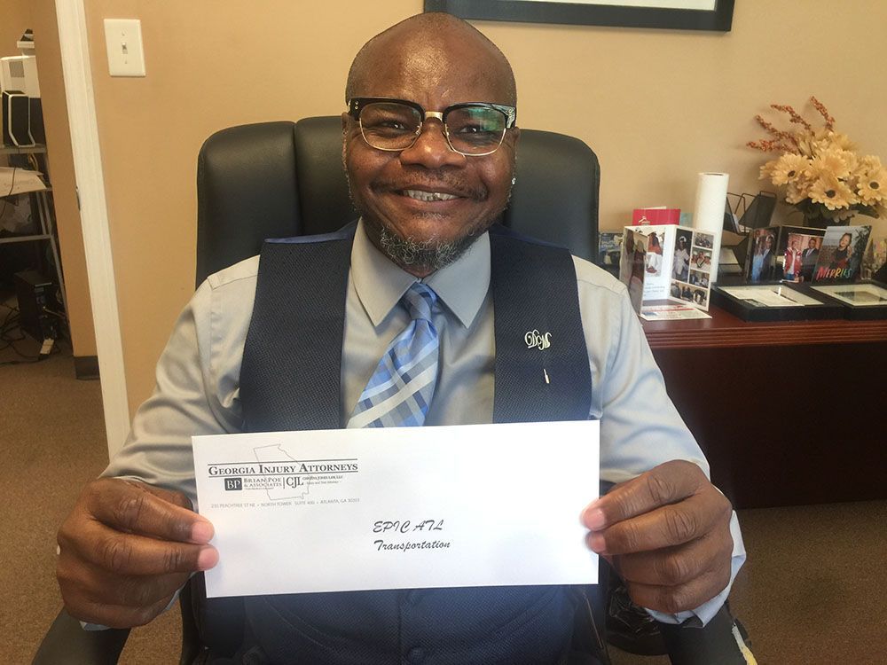 A man in a vest and tie is holding an envelope