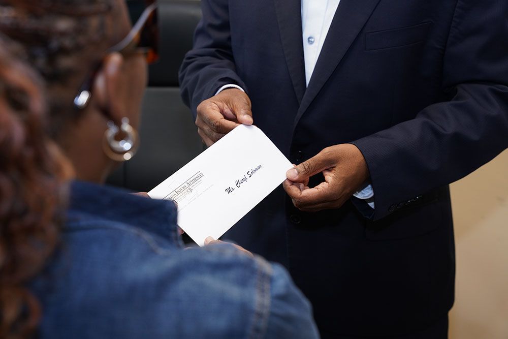 Brian D. Poe, Esq. handing an envelope to a client