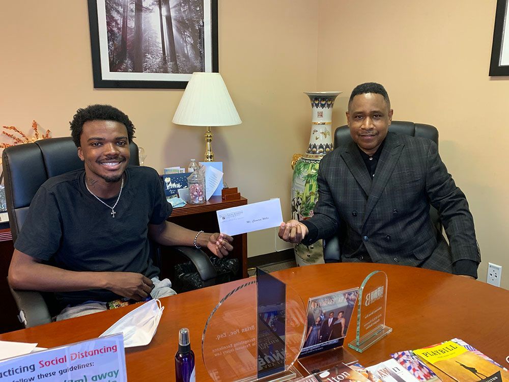 Two happy men are sitting at a table holding a check