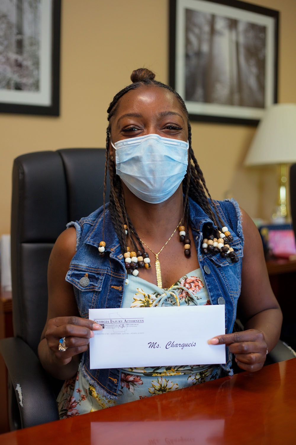 A sitting at a desk holding an envelope